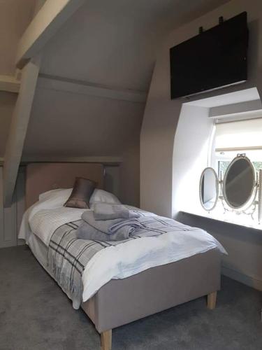 - une chambre avec un lit et deux miroirs sur le mur dans l'établissement The Swan, à Topcliffe