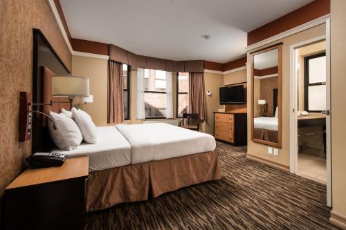 Habitación de hotel con cama grande y TV en The Hotel at Fifth Avenue, en Nueva York