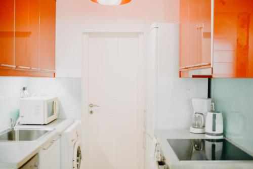 una cucina con lavello e microonde di Best House, Rooftop Aprtm., Marina Zeas Piraeus a Pireo