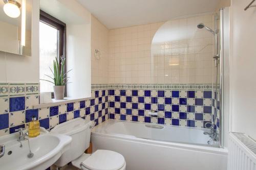 a bathroom with a tub and a toilet and a sink at Tethera at Coal Yeat in Spark Bridge