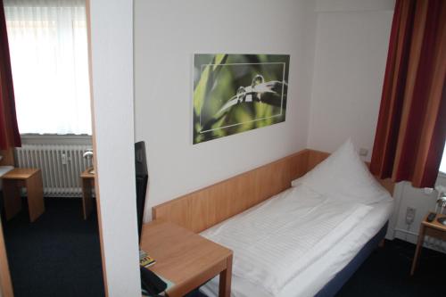a small room with a bed and a table at Hotel Römerhof Hanau by Trip Inn in Hanau am Main