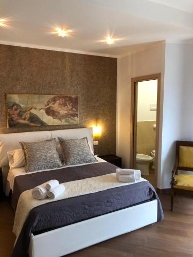 a bedroom with a large bed with two towels on it at Beb oasi marina in Campofelice di Roccella