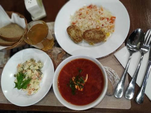 a table with two plates of food and a bowl of soup at Predslava Hotel in Kyiv