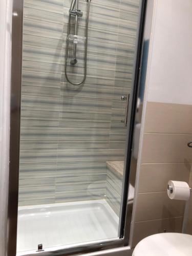 a shower with a glass door in a bathroom at Beb oasi marina in Campofelice di Roccella