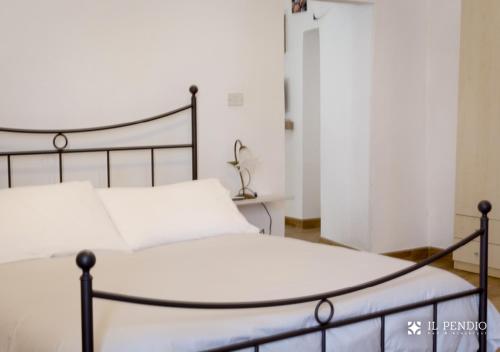 een slaapkamer met een bed met witte lakens bij Il Pendio in Castellaneta