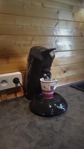 a coffee maker with a cup on a table at Chalet Les Lilas in Colmar