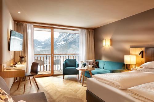 Habitación de hotel con cama y balcón en Hotel die Wälderin-Wellness, Sport & Natur, en Mellau