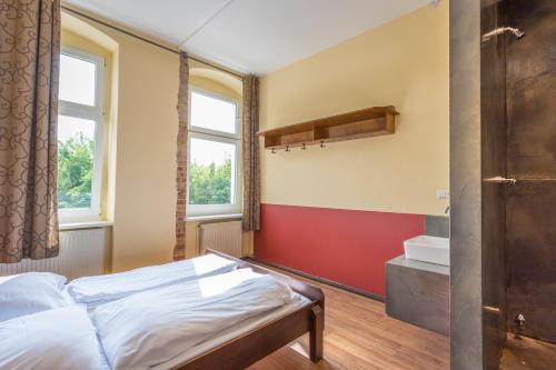 a bedroom with a bed and a red wall at Sunflower Hostel Berlin in Berlin