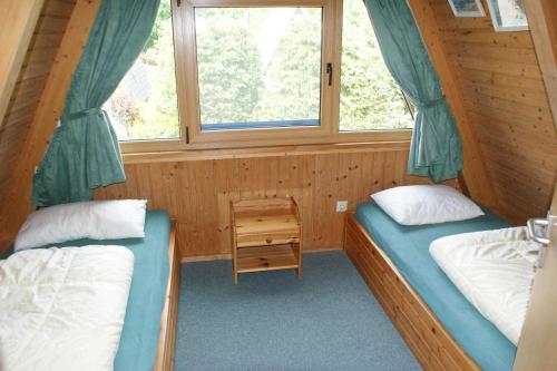 two beds in a small room with a window at Urlaub fuer die ganze Familie in Damp