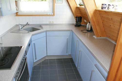 a kitchen with blue cabinets and a sink and a window at Urlaub fuer die ganze Familie in Damp