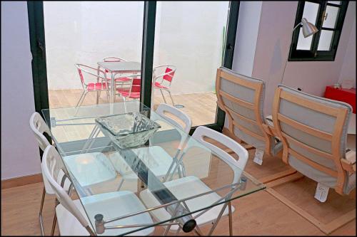 カディスにあるApartamento Solano Cádizの窓付きの客室で、ガラスのテーブルと椅子が備わります。