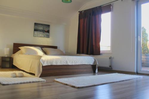 a bedroom with two beds and a large window at Hotel Kika in Pristina