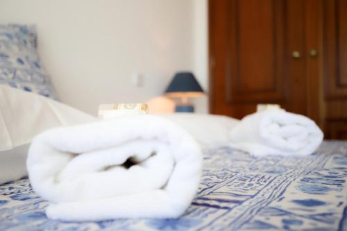 two towels are sitting on top of a bed at Sotto Mayor Residence in Figueira da Foz