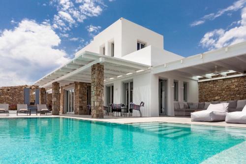 a villa with a swimming pool and a house at Luxury Villa Artemis by Mykonos Luxury in Elia Beach