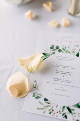 a wedding invitation on a table with flowers at Riverbank, Country Pub and Guesthouse in Carrickmacross