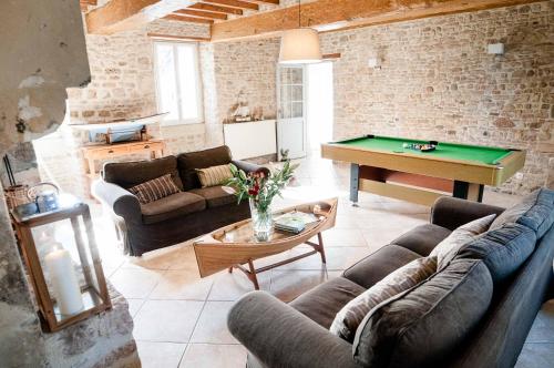 a living room with couches and a pool table at La demeure d'Ervée in Isigny-sur-Mer
