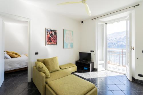 a living room with a couch and a tv and a bed at Lovely Apartment Overlooking Lake Como by Rent All Como in Carate Urio
