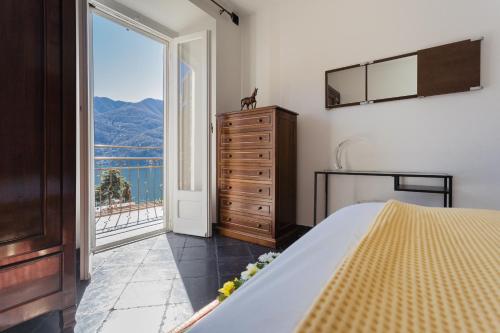 a bedroom with a bed and a large window at Lovely Apartment Overlooking Lake Como by Rent All Como in Carate Urio