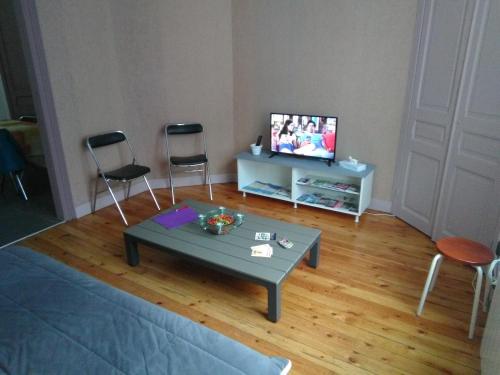 salon ze stołem, 2 krzesłami i telewizorem w obiekcie Gîte sur St Pol sur mer de 2 à 8 couchages w mieście Saint-Pol-sur-Mer
