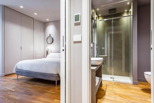 a bedroom with a bed and a sink and a bathroom at Ferrini Home - Etnea Collection in Catania