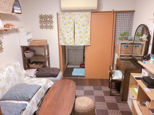 a living room with a couch and a table at Ryokoheya Tenchokan in Osaka