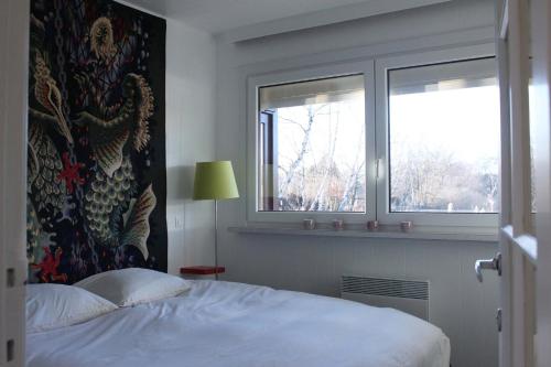 1 dormitorio con 1 cama y 2 ventanas en My Secret Garden en Diepenbeek