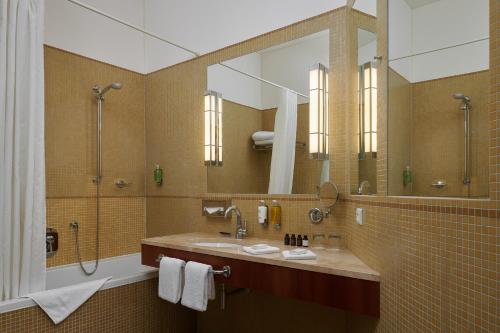 a bathroom with a sink and a large mirror at Ventana Hotel Prague in Prague