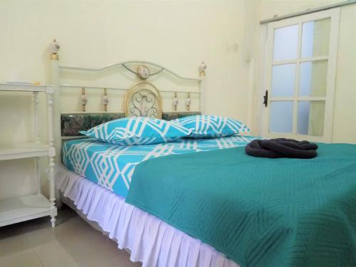 1 dormitorio con 1 cama con sábanas azules y blancas en Bukir Five, en Malang