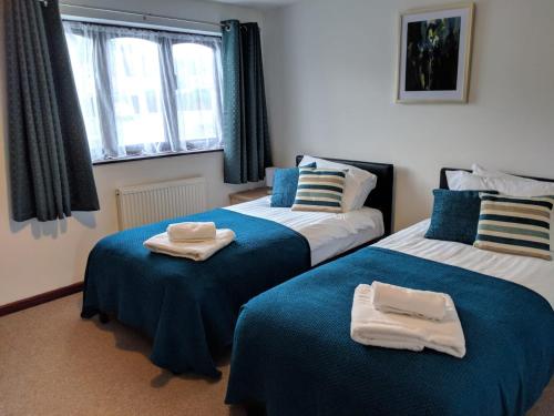 um quarto com 2 camas e toalhas em Princes Lodge em Telford