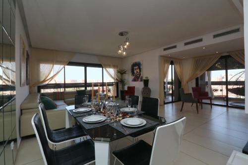 a dining room and living room with a table and chairs at Sweet Jacob's Appartment Gueliz City Center in Marrakech
