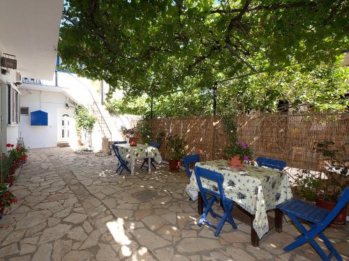 a patio with tables and chairs and a fence at Sweet Memories Beach Houses in Mesongi