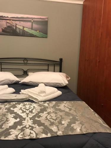 a bedroom with a bed with two white towels on it at Pinpoint Rooms in Mesolongion