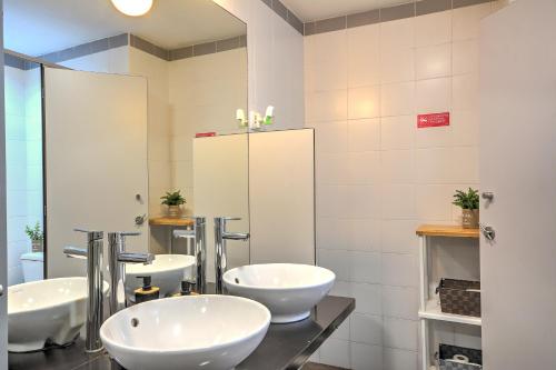 a bathroom with two sinks and a large mirror at Inn Bairro Alto B&B / B.A Sweet in Lisbon