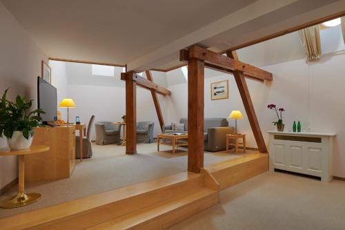a living room with wood beams and a living room with a couch at Ventana Hotel Prague in Prague