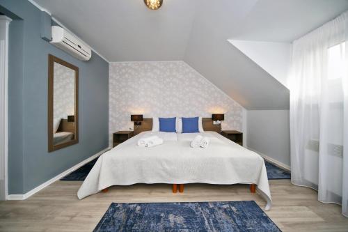 a bedroom with a large bed with blue walls at Várkapu Panzió in Eger