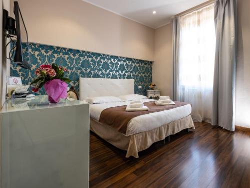 Un dormitorio con una cama grande y una ventana en Antico Hotel Moderno, en Piombino