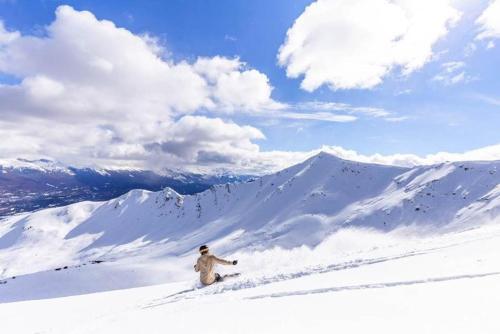 a man standing on top of a snow covered mountain at Whistler's Inn in Jasper