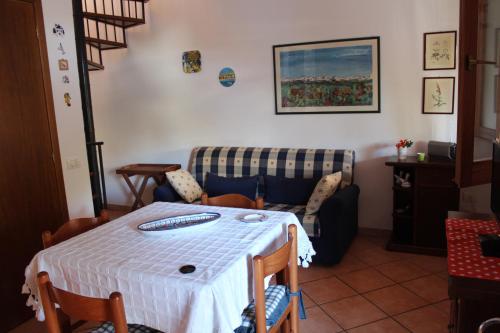 een woonkamer met een tafel en een bank bij Villetta con giardino Mandarino Macari in Macari