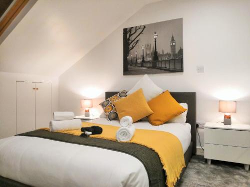 a bedroom with a large white bed with yellow pillows at Horse Fair Apartments in Birmingham City Centre by HF Group in Birmingham