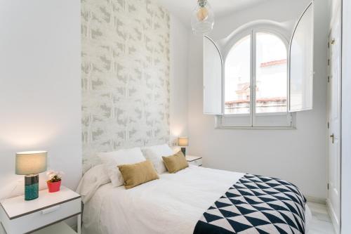 - une chambre blanche avec un lit et une fenêtre dans l'établissement Veoapartment García de Vinuesa, à Séville