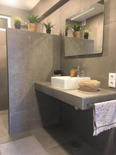 a bathroom with a sink with plants on the wall at Bico das flores in Praia de Mira