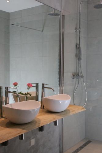 Dois lavatórios num balcão na casa de banho com chuveiro em Hotel Duinrand Drunen em Drunen