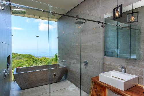 a bathroom with a sink and a bath tub at Rancho Pacifico - Boutique Hotel for Adults in Uvita
