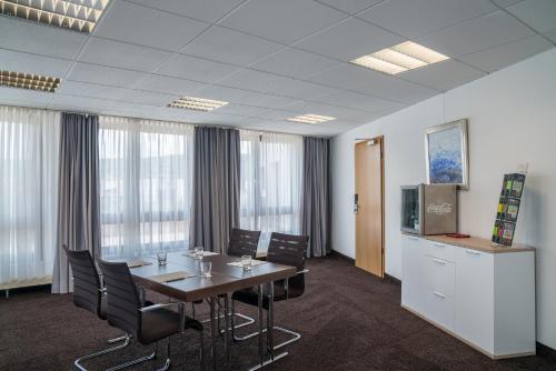 a conference room with a table and chairs and a tv at LOFTSTYLE Hotel Gerlingen, Sure Hotel Collection by Best Western in Gerlingen