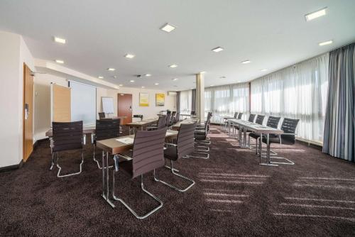 a conference room with tables and chairs and windows at LOFTSTYLE Hotel Gerlingen, Sure Hotel Collection by Best Western in Gerlingen