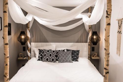 1 dormitorio con cama con dosel y almohadas blancas y negras en Holiday Home Wonderland with private Spa/Wellness, en Ralingen