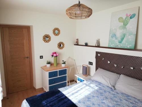 een slaapkamer met een bed met een blauw dekbed bij Apartamento La Muralla de Llanes in Llanes