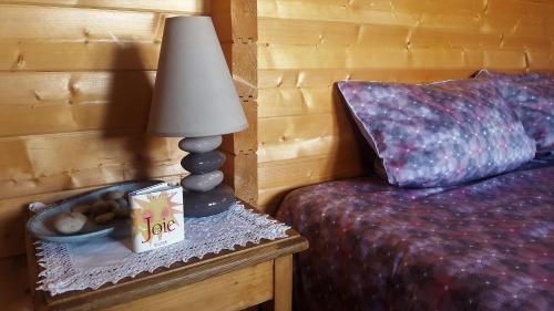 a bedroom with a bed and a lamp on a table at Chalet Les Lilas in Colmar