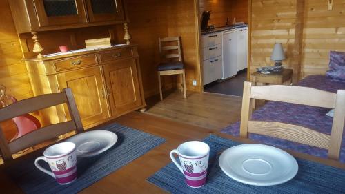 a room with two cups and plates on a table at Chalet Les Lilas in Colmar