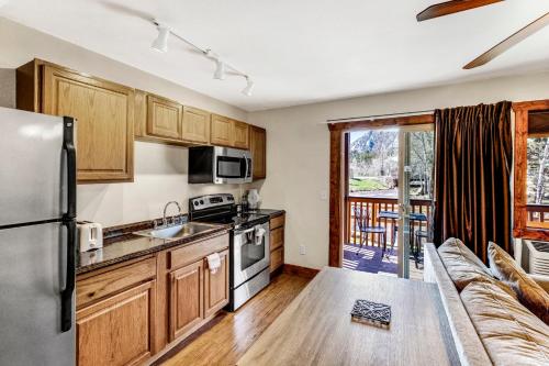 a kitchen with a couch and a refrigerator at Murphy's River Lodge in Estes Park